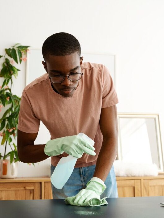 front-view-man-servant-cleaning-table_23-2149482297
